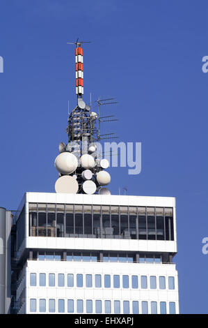 Grappe de différentes antennes micro-ondes en haut d'un immeuble de bureaux moderne élevé Banque D'Images