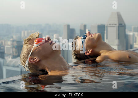 Les adolescents se détendre dans une piscine à débordement, Marina Bay Sands, Singapour, Singapour Ville Banque D'Images