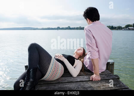 Jeune couple relaxant de l'eau du lac jetty Banque D'Images