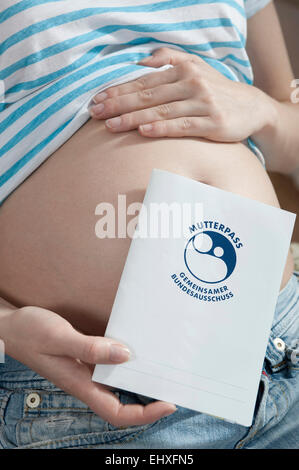 Pregnant woman holding journal livre protocole maternité Banque D'Images