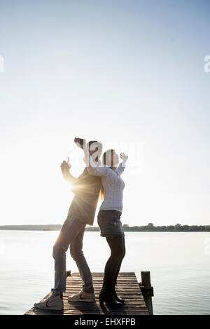 Young happy couple dancing jetty sunset Banque D'Images