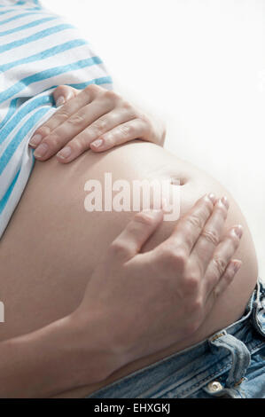Close up femme enceinte estomac sur les mains Banque D'Images