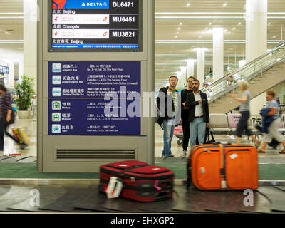 Les personnes en attente de bagages à la réclamation de bagages carousel au l'aéroport international de Pudong à Shanghai, Chine Banque D'Images