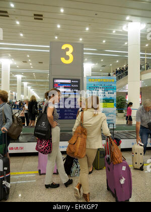 Les personnes en attente de bagages à la réclamation de bagages carousel au l'aéroport international de Pudong à Shanghai, Chine Banque D'Images