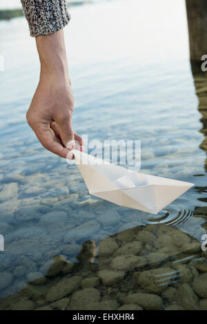 Portrait jeune homme papier lancement de l'eau bateau Banque D'Images