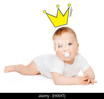 Smiling baby lying on floor avec dummy dans la bouche Banque D'Images