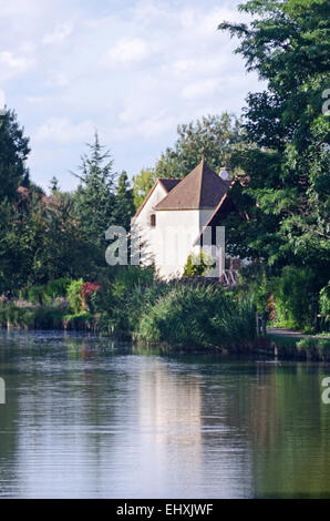 Un jardin luxuriant entoure une vieille maison sur le Canal du Centre, près de Chalon-sur-Saône, Bourgogne, France. Banque D'Images