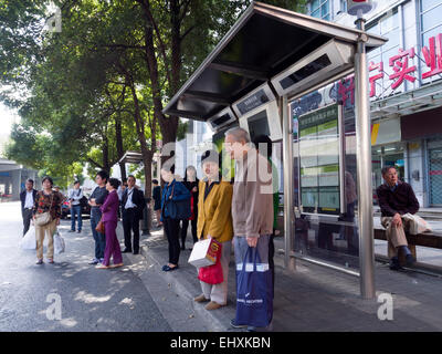 Les gens qui attendent à l'arrêt de bus à Shanghai, Chine Banque D'Images