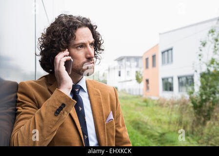 Portrait jeune homme cheveux longs fonction cell phone Banque D'Images