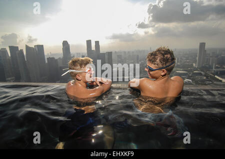 Adolescents dans une piscine à débordement, Marina Bay Sands, Singapour, Singapour Ville Banque D'Images