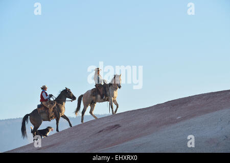 USA, Wyoming, deux cowgirls équitation et leur chien dans badlands Banque D'Images