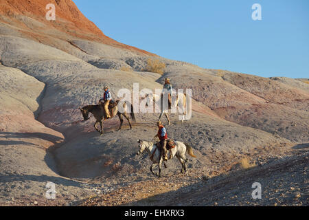 USA, Wyoming, deux cowgirls et un cowboy équitation dans badlands Banque D'Images