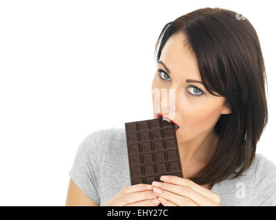 Attractive young woman eating a dark chocolate bar Banque D'Images