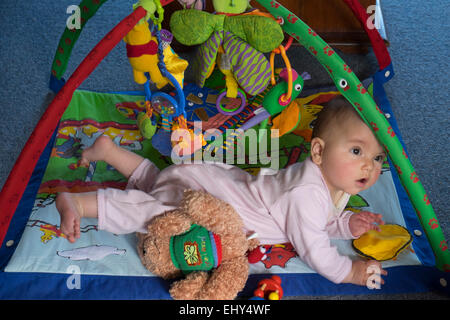 8 mois bébé fille jouant sur marbre avec jouet interactif Banque D'Images