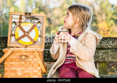 Girl holding cup outdoors, portrait Banque D'Images
