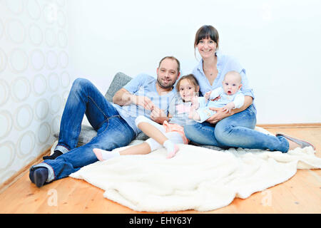 Famille à la maison de détente sur blanket Banque D'Images