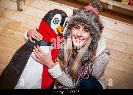 Jeune femme posant avec penguin du prince Banque D'Images