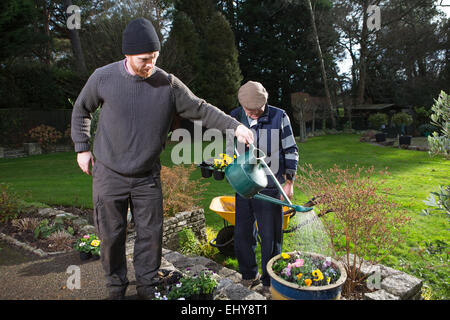 Man watering flowers, Bournemouth, Dorset County, au Royaume-Uni, en Europe Banque D'Images