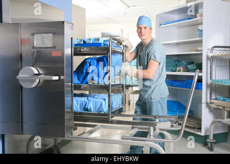 Les hommes qui travaillent sur un lieu de stérilisation à l'hôpital de placer un char. Banque D'Images