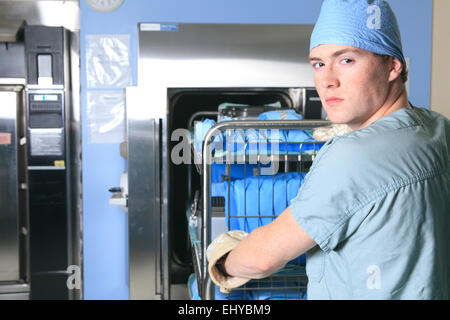 Les hommes qui travaillent sur un lieu de stérilisation à l'hôpital de placer un char. Banque D'Images