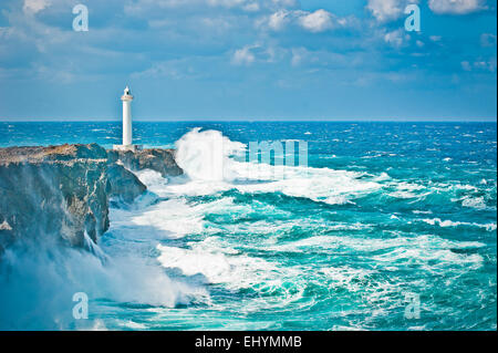 Vagues se briser sur les rochers par un phare à la suite d'un typhon, Okinawa, Japon Banque D'Images