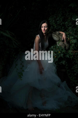 Mid adult woman sitting entre Ivy et rochers