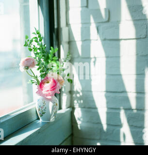 Ranunculus dans un vase sur le rebord de la fenêtre Banque D'Images