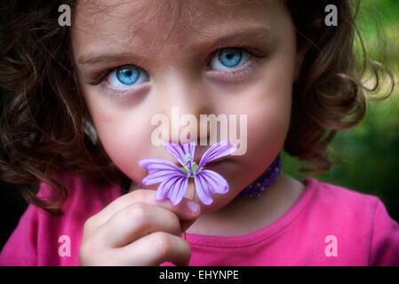 Portrait d'une fille qui sent une fleur sauvage Banque D'Images