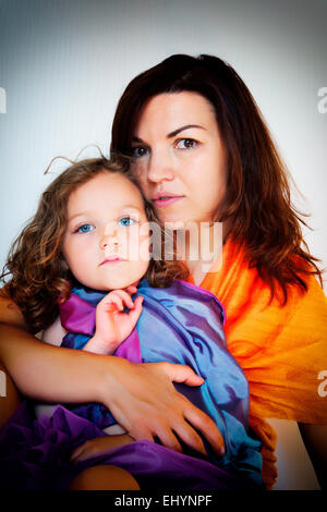 Portrait d'une fille assise sur les genoux de sa mère Banque D'Images