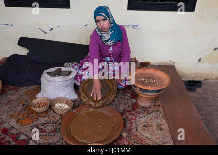 Femme d'argan (Argania spinosa de broyage d'amandes) pour le processus de fabrication traditionnelle de l'huile d'argan, vallée de l'Ourika, Atlas Pe Banque D'Images