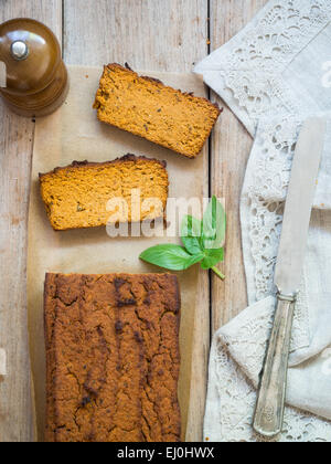 Photo verticale d'un pain composé de pois chiches végétariens pate sur une table en bois rustique, deux pièces coupées. Vue de dessus. Banque D'Images