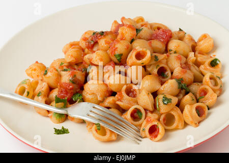 Coquilles de pâtes coude Gomiti aromatisé d'arrabbiata tomate, Ail et sauce chili et servi avec du persil haché Banque D'Images