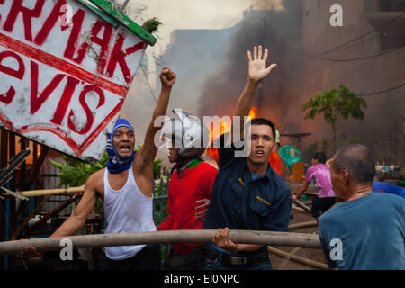 Les gens se coordonnent pour lutter contre un incendie qui se propage et brûle des centaines de maisons dans un quartier dense de Penjaringan, Jakarta, Indonésie. Banque D'Images