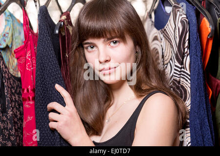 Portrait of a Teenage girl en face de certaines robes Banque D'Images