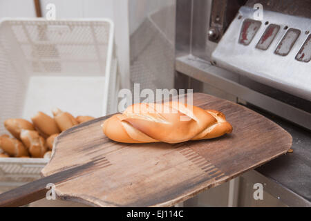 Baker tranche d'un morceau de pain frais. Processus de fabrication de pain espagnol Banque D'Images