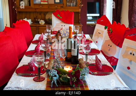 Vue horizontale d'une table dressée prête pour un repas de Noël en famille. Banque D'Images