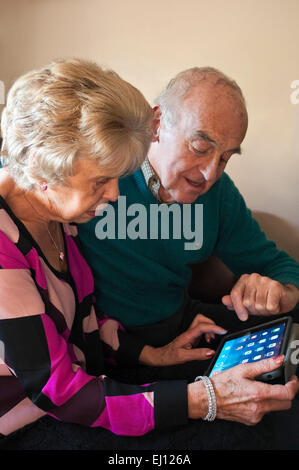 Portrait vertical d'un couple de personnes âgées à l'aide d'un ipad ensemble. Banque D'Images