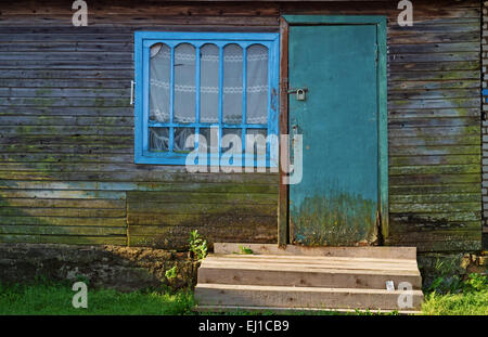 Maison de village avec porte carte perdue sur les marches de la véranda en bois. Banque D'Images