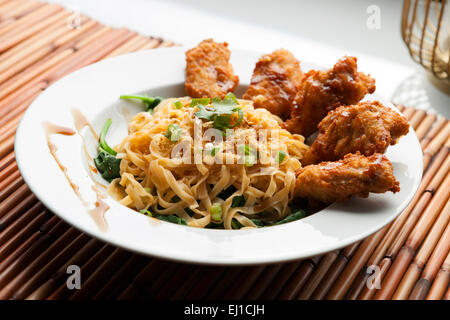 Ailes de poulet avec des nouilles et épinards Banque D'Images