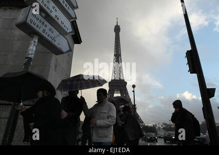 Les gens sous des parasols sur le pont d'Iéna en face de la Tour Eiffel à Paris, France. Banque D'Images