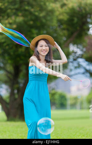 Young woman playing bubbles et heureusement, smiling Banque D'Images