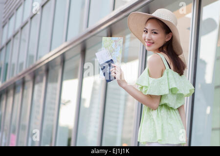 Young woman holding passeport et billet d'avion avec le sourire, Banque D'Images