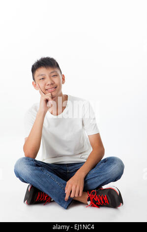 Teenage boy sitting with blindfold and smiling at the camera Banque D'Images