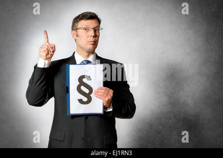 Homme d'affaires en costume sombre est titulaire d'un dossier avec un gros paragraphe sign Banque D'Images