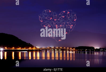 Coeur de l'éclat d'Artifice célébrer plus de bridge du lac Kawaguchiko la nuit avec le mont Fuji au Japon, l'arrière-plan Banque D'Images