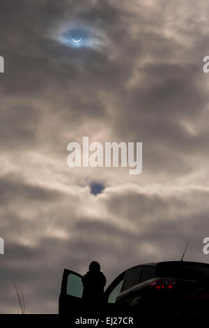 Ilkley Moor, West Yorkshire, Royaume-Uni. Le 20 mars 2015. Silhouetté personne tient à regarder les éclipse solaire partielle sur le côté d'une voiture. Crédit : Ian Lamond/Alamy Live News Banque D'Images