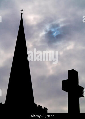 Duffield, Derbyshire, Royaume-Uni 20 mars 2015 - une éclipse partielle du soleil par la lune à côté de la flèche de l'église St Alkmund de Duffield Derbyshire UK . Le spectaculaire à eclipse autour de 9h30 était visible sur la plupart des îles britanniques. Banque D'Images