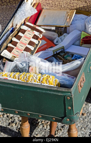 Une valise vintage remplie de notions de couture et garniture en un marché aux puces à Gigny-safe-Saône, Bourgogne, France. Banque D'Images