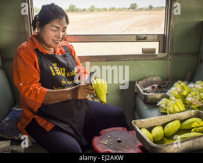 Prachinburi, Prachinburi, Thaïlande. Mar 20, 2015. Un vendeur de coupe mangue mangues avant de les vendre sur le train pour 3e classe Kabin Buri. Les chemins de fer de l'état de la Thaïlande (SRT), créée en 1890, exploite 4 043 kilomètres de voie à voie métrique qui atteint la plupart des régions de la Thaïlande. Une bonne partie de la piste et de nombreux trains sont souvent mal entretenus et les trains sont en retard. Accidents et d'incidents sont également monnaie courante. Les gouvernements successifs, y compris l'actuel gouvernement militaire, ont promis d'améliorer les services ferroviaires. Le gouvernement militaire a signé des contrats avec la Chine d'upgr Banque D'Images