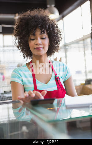 Joli tablier rouge en employé using calculator Banque D'Images